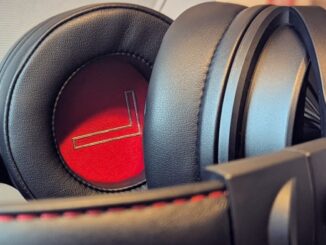 Close-up of OneOdio Studio Max 1 headphones showing the black leather earcups with a red inner lining and padded headband.