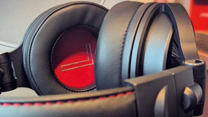 DJ-Ready Headphones with Epic Battery Close-up of OneOdio Studio Max 1 headphones showing the black leather earcups with a red inner lining and padded headband.