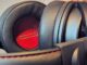 Close-up of OneOdio Studio Max 1 headphones showing the black leather earcups with a red inner lining and padded headband.