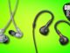 Two pairs of Shure and Beyerdynamic in-ear monitors on a green background