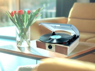A very unconvincing image showing the Groov-e Vintage Turntable next to tulips on a wooden coffee table.