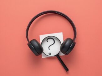 Magnifying glass between a pair of headphones