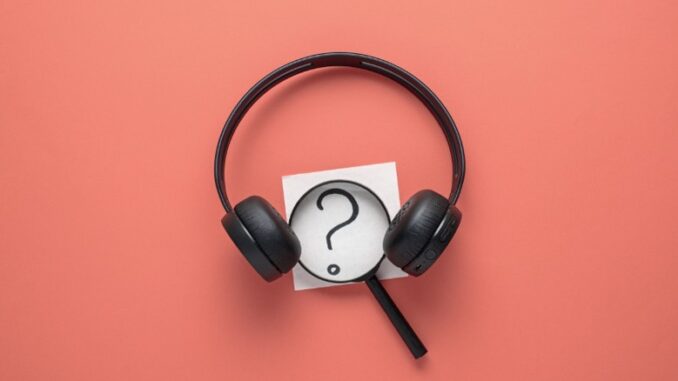 Magnifying glass between a pair of headphones