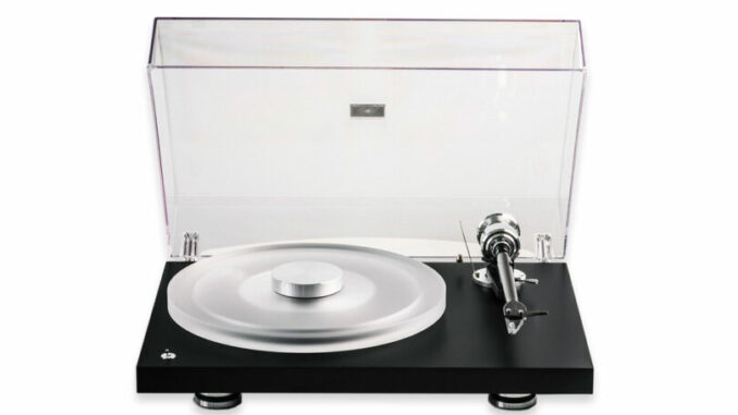 A modern turntable with a transparent dust cover, a silver platter, and a black base, viewed from the front against a white background.