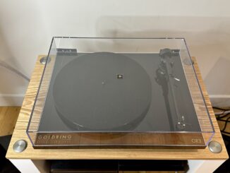 Goldring GR3 turntable, with the dustcover closed, as part of a sound system setup on a wooden surface